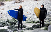 Surfers walk the beach in Yakutat, Alaska.