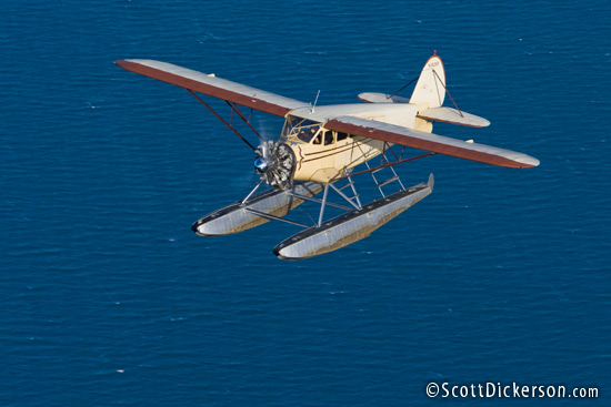 Air to air aerial photo of 1933 Stinson JR SR on floats flying over Kachemak Bay, Alaska.