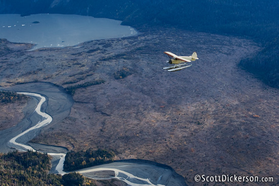 Air to air aerial photo of 1933 Stinson SR JR seaplane flying over Grewingk Lake and river, Alaska.