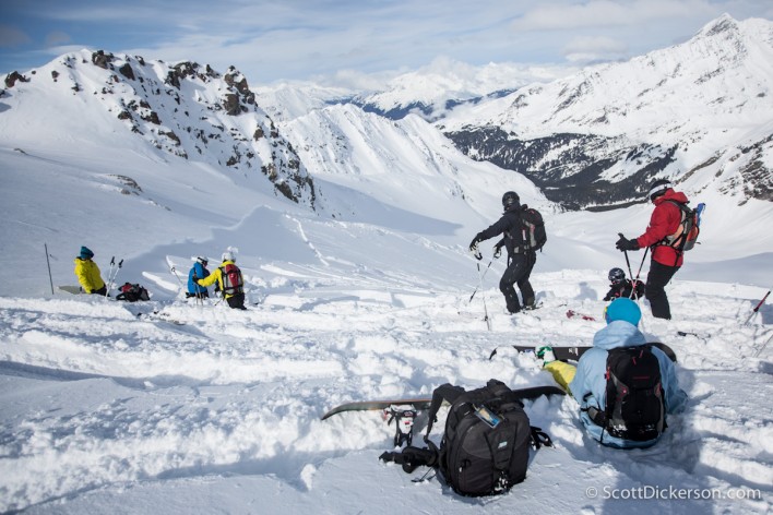 Skiiers watch as an avalanche slides below them while heliskiing in Alaska.