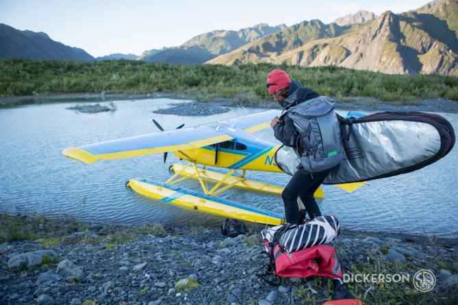 Jason McCaffrey loading his kitesurfing gear into a seaplane after kitesurfing in a glacial lake in Alaska.