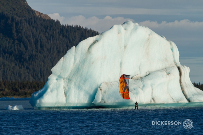 Jason Slezak, kitesurf ambassador for Patagonia, kiting near a huge iceberg in a glacial lake in Alaska.